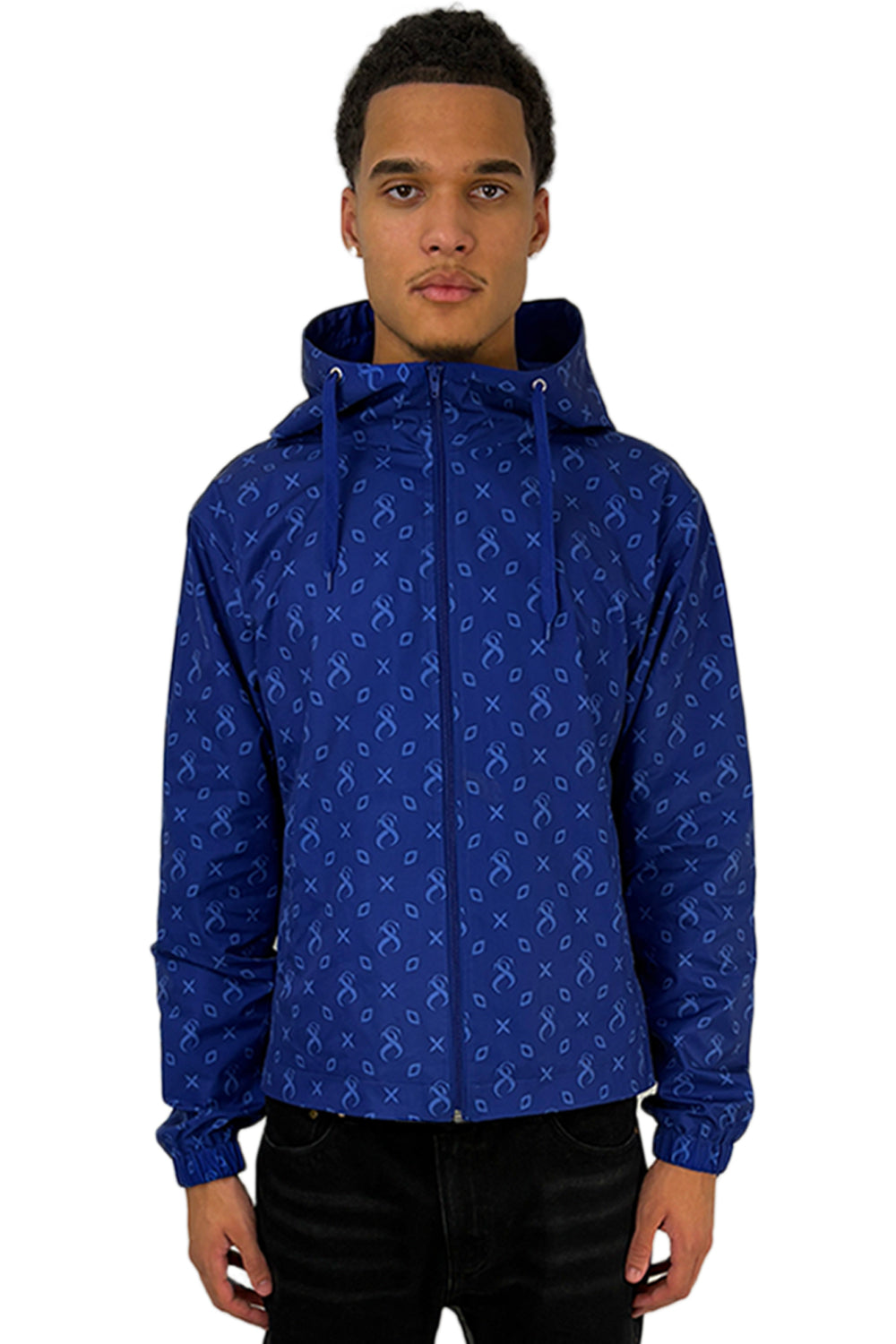 Model trägt die Atlantic Windbreaker in Blau mit charakteristischem Muster und Kapuze, die sich durch modernes Design und Passform auszeichnet.