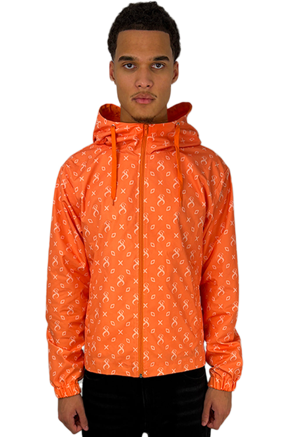 Model trägt die Papaya Windbreaker in Orange mit charakteristischem Muster und Kapuze, die sich durch modernes Design und Passform auszeichnet.
