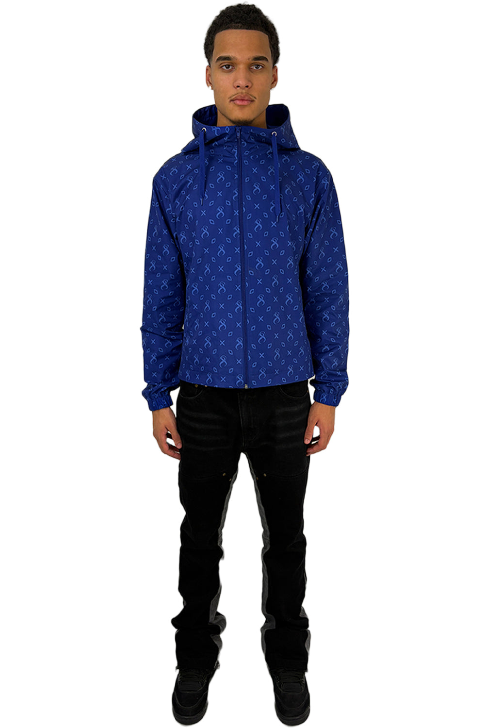  Model trägt eine Atlantic Windbreaker mit durchgehendem Muster und modernem Design, kombiniert mit einer schwarzen Hose.