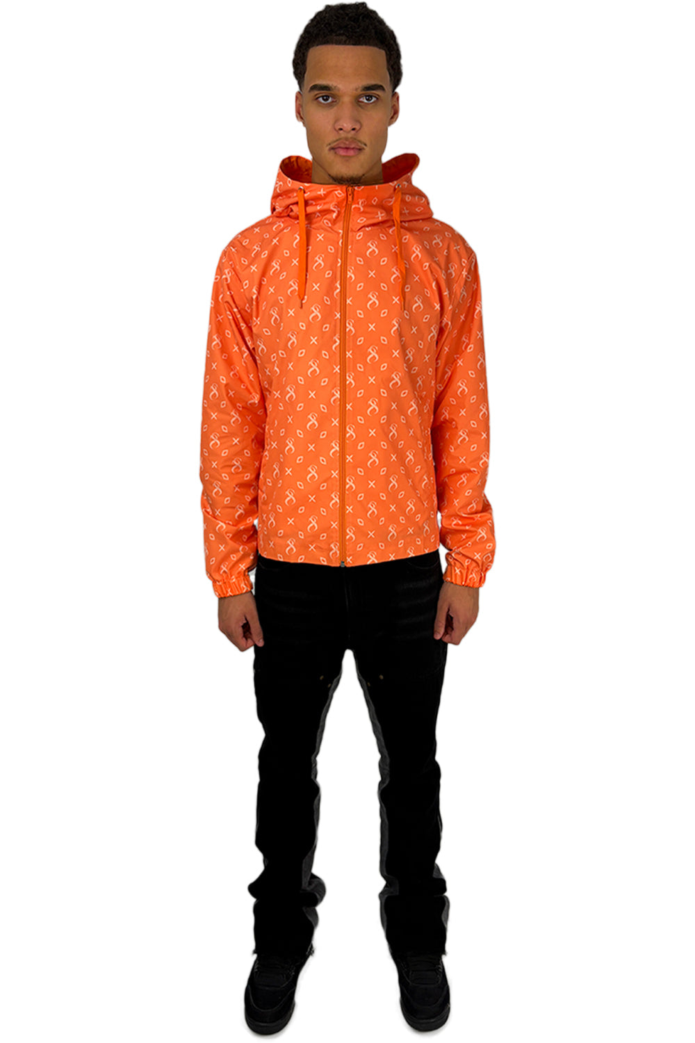 Model trägt eine Papaya-Windjacke mit durchgehendem Muster und modernem Design, kombiniert mit einer schwarzen Hose.