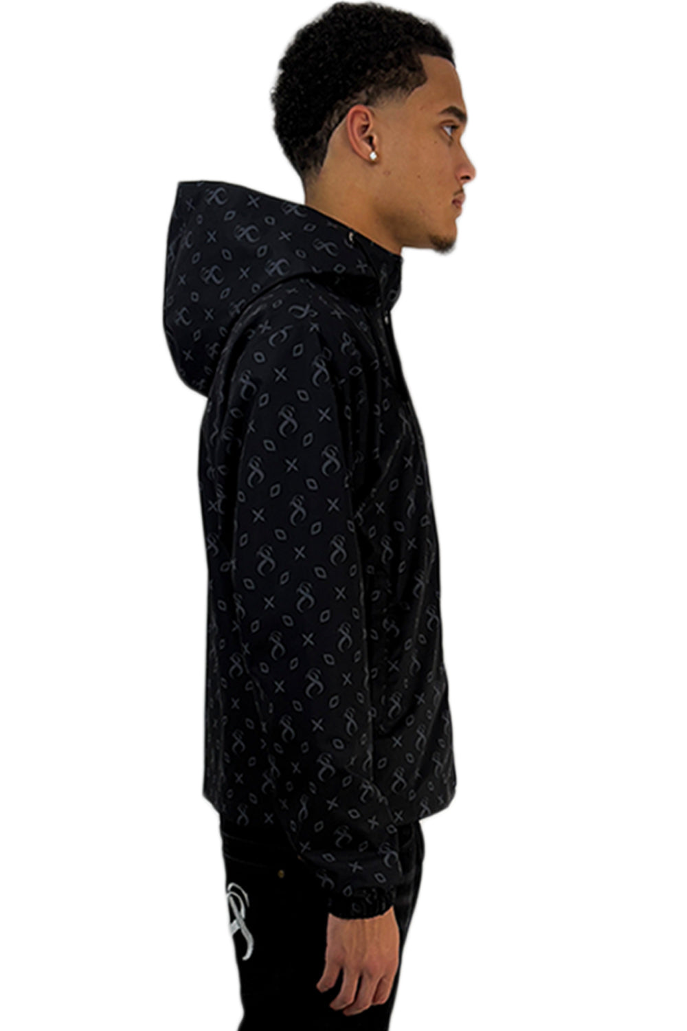  Model im Seitenprofil mit Midnight Windbreaker mit durchgehendem Sterlingz-Muster und Kapuze.