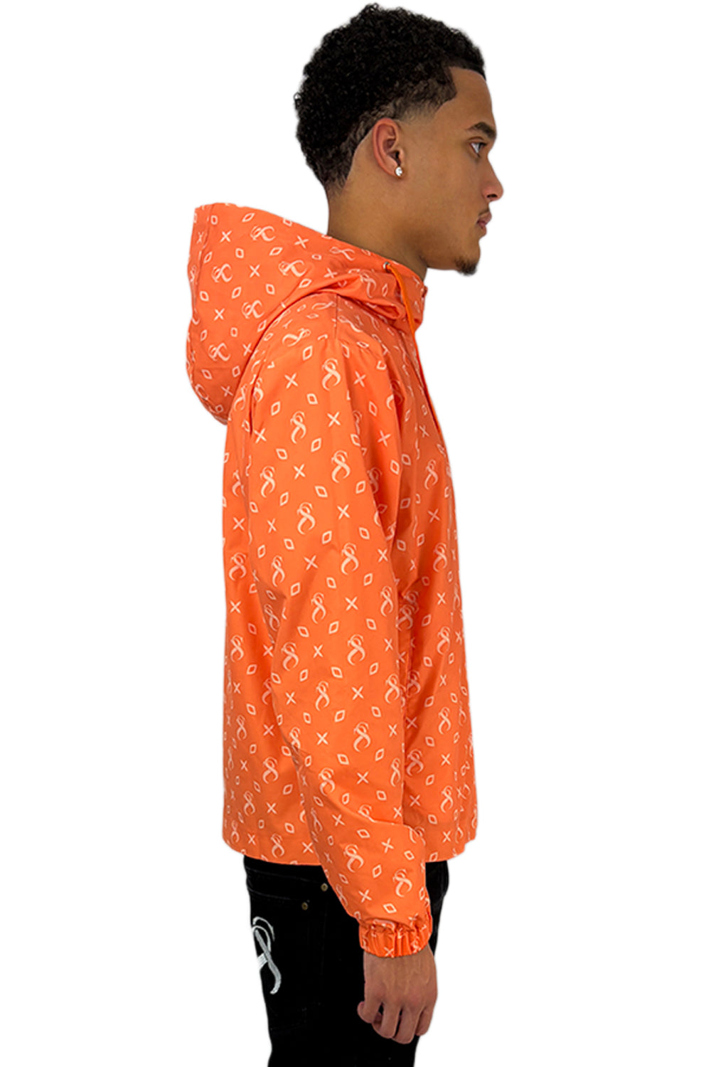 Model im Seitenprofil mit der Papaya Windbreaker Jacke mit durchgehendem Sterlingz-Muster und Kapuze.