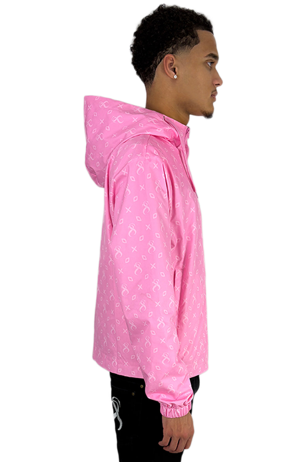 Side view of a man wearing the Miami Windbreaker in pink with a hood and all-over Sterlingz pattern.